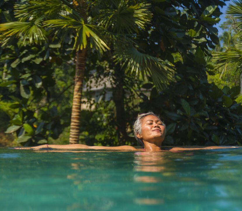 Luxury solo female traveller takes dip in invigorating pool