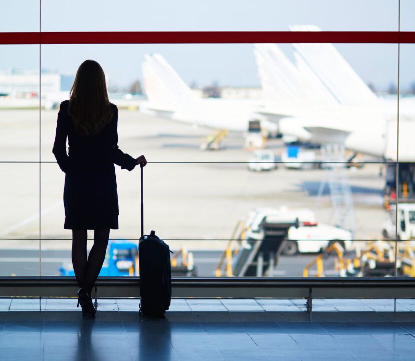 Woman travelling solo at an airport waiting for her flight to depart.