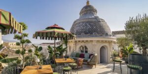 A dining area on the terrace at the luxury hotel with an array of chairs, tables and greenery.