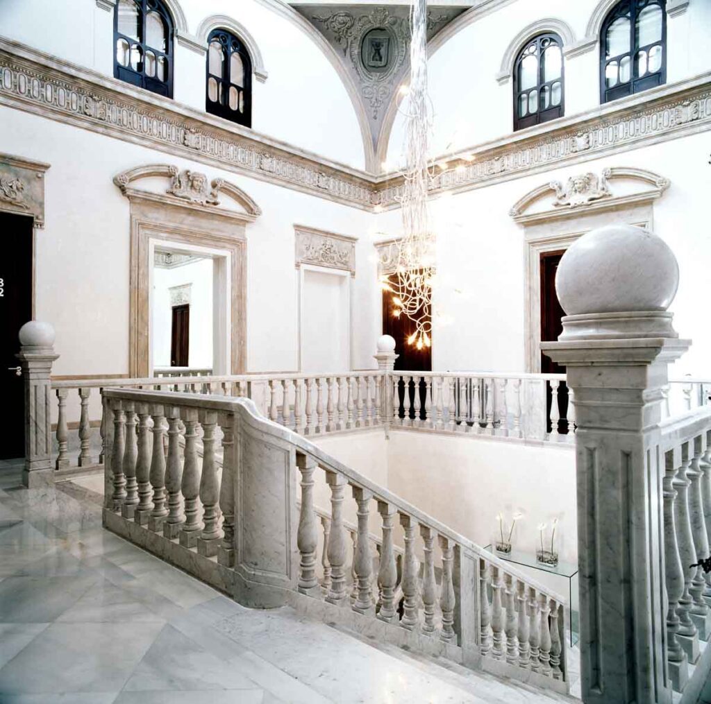 A grand marble staircase at the luxury Hospes Palacio de los Patos.