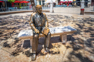 Pablo Picasso Statue sitting on a bench at Plaza de la Merced Square - Malaga, Andalusia, Spain