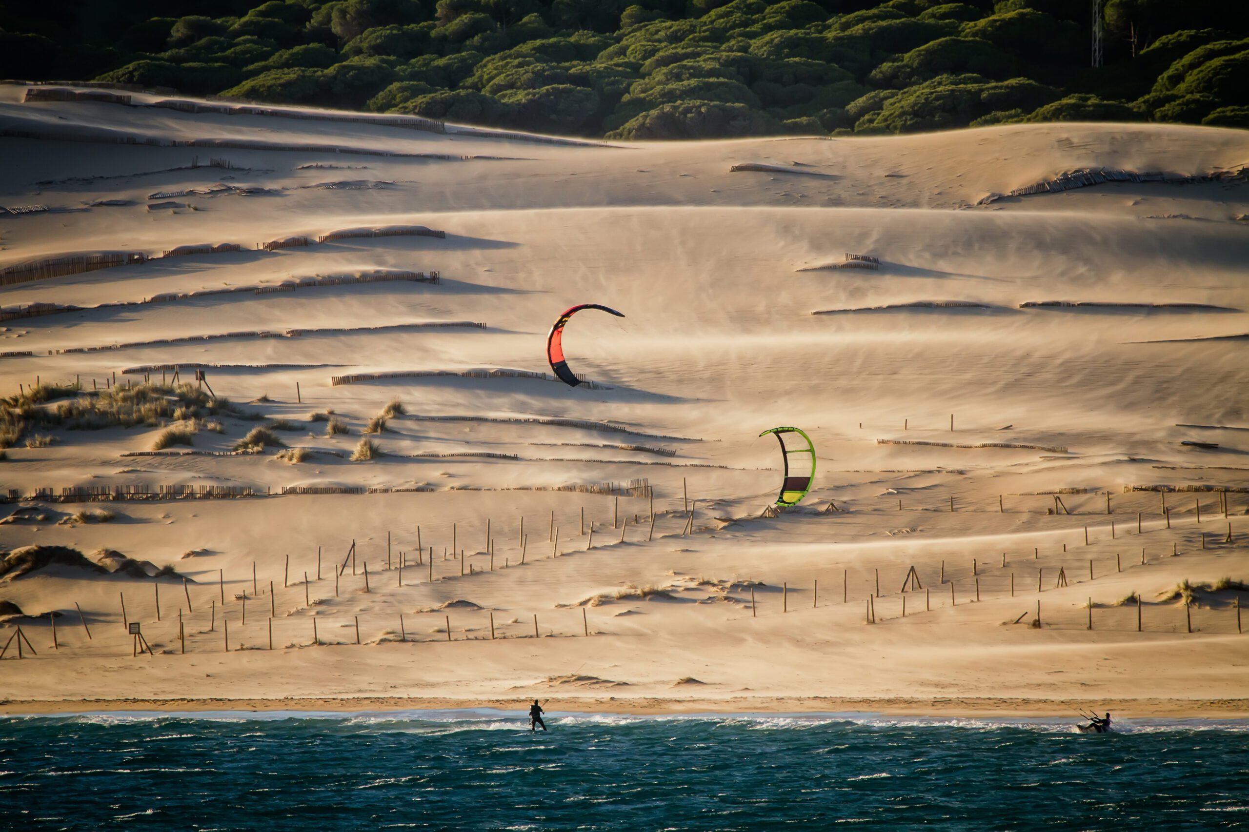 Kitesurfers in the distance in front of the enormous sand dunes found in Tarifa Spain