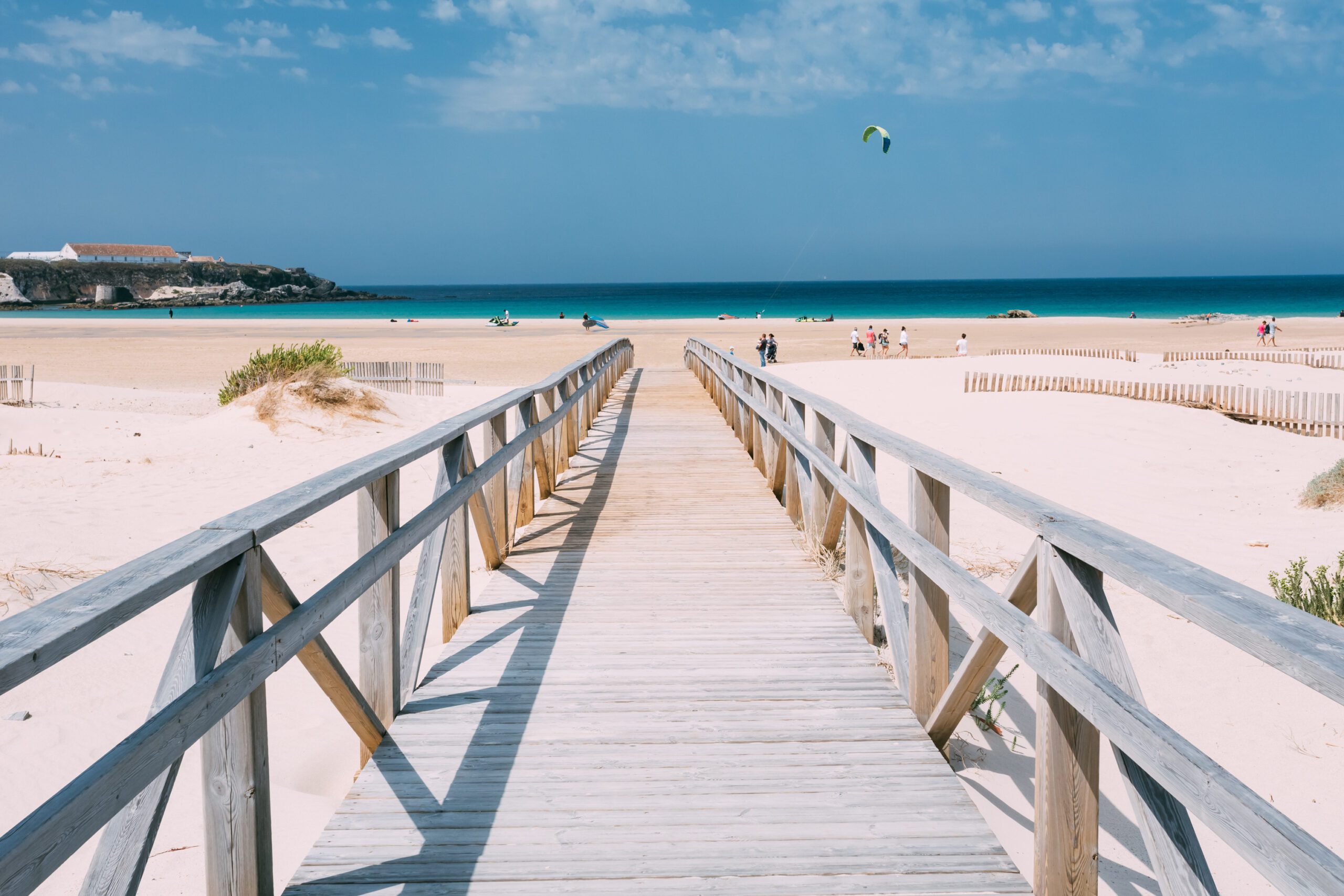 A ristic wooden footbridge onto the pinky white sands of the beach in Tarifa Spain.