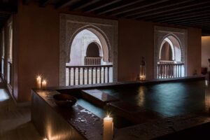 An an Arab bath with candles lit along the edge.