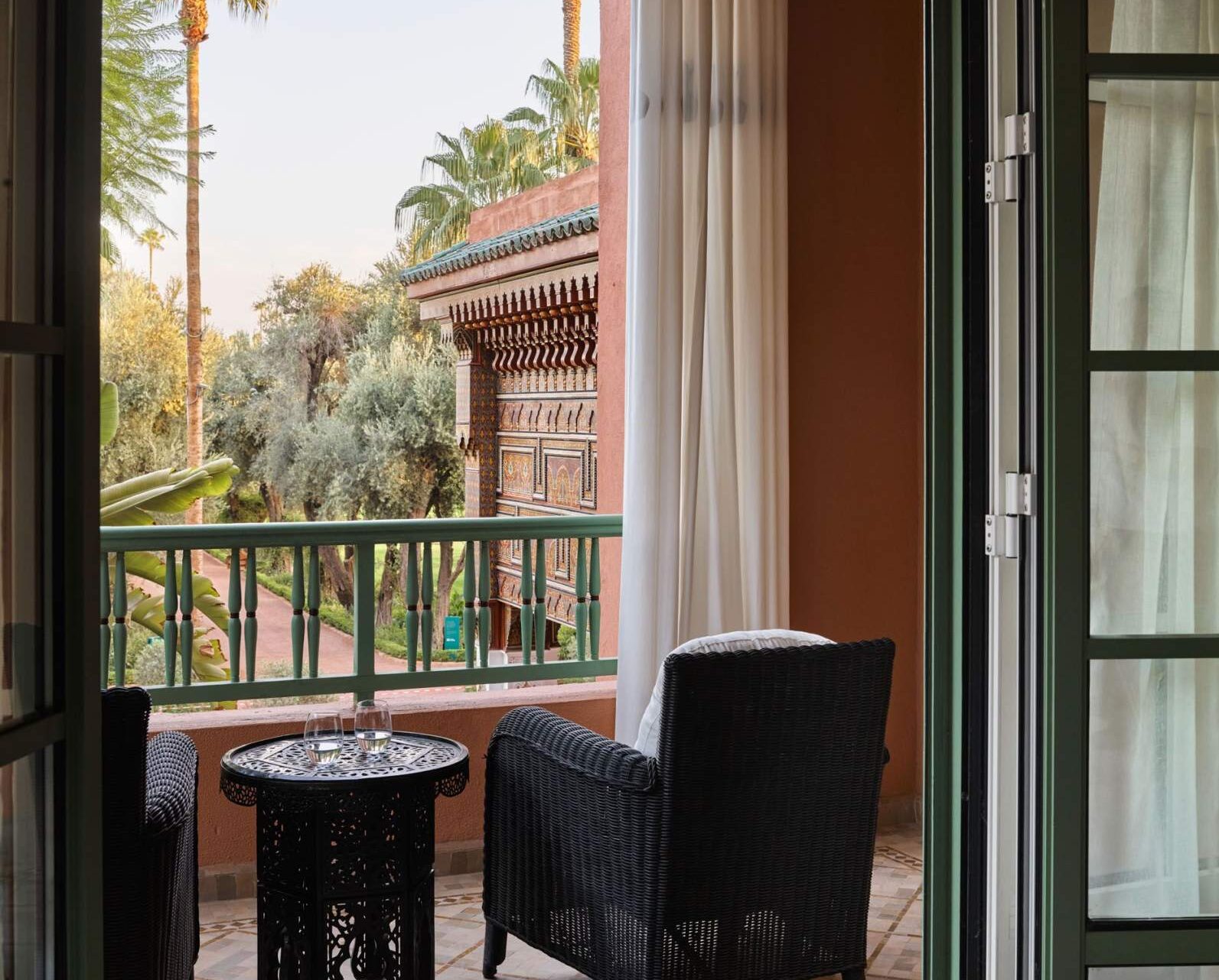 A sophisticated balcony arrangement featuring a table and chairs facing onto stunning views of Marrakech.