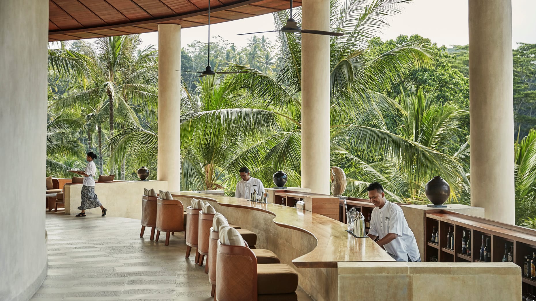 A sophisticated bar enveloped by palm trees, creating the perfect luxury travel escape.