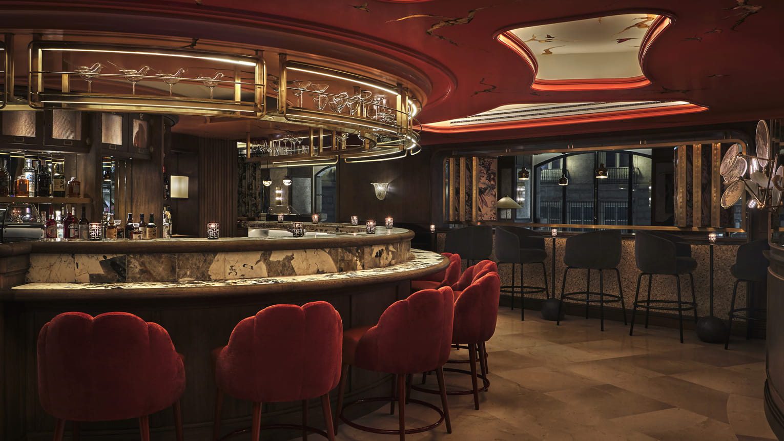 A bar at the luxury hotel with seating surrounding the bar.