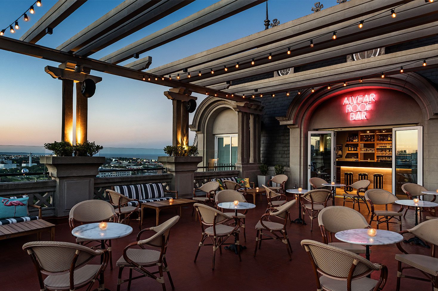 A rooftop bar with tables, chairs and incredible views over Buenos Aires.