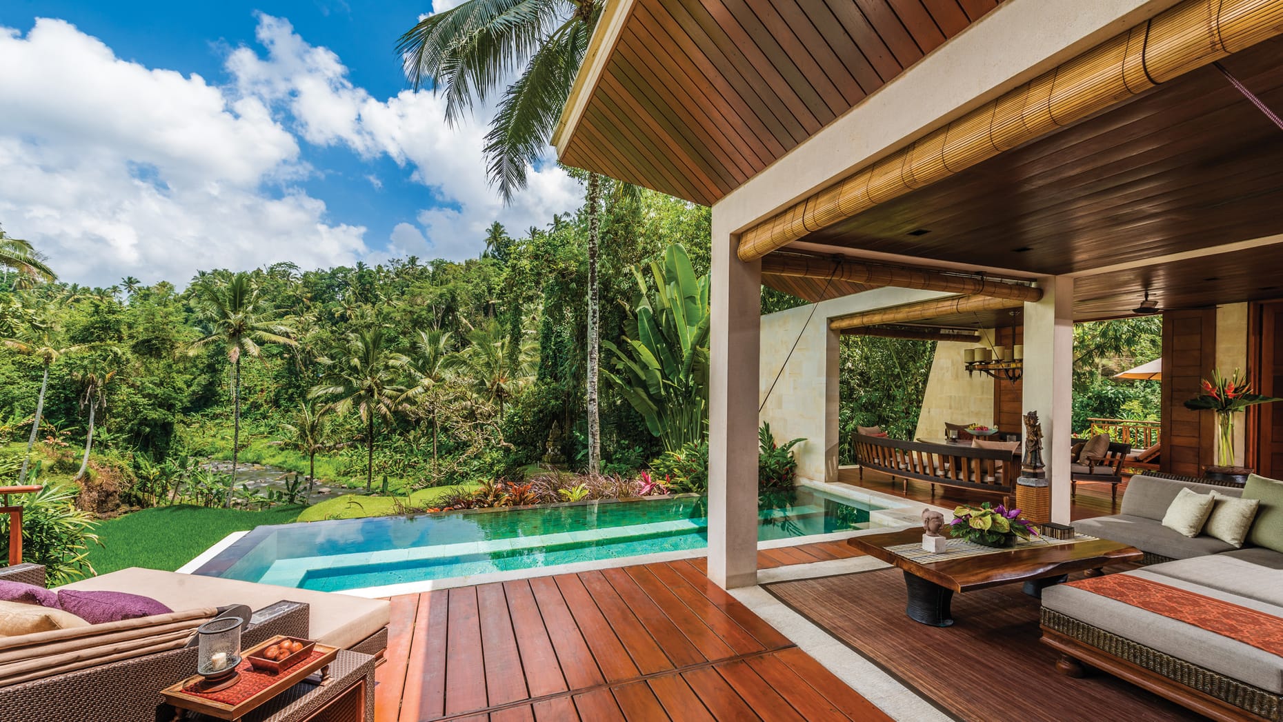 A view from a luxury room in the hotel, showcasing the outdoor furniture, pool and the incredible Indonesian trees and greenery.