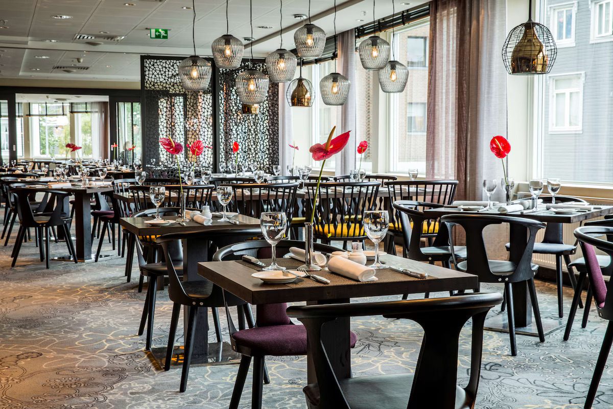 A luxury dining room with lots of perfectly laid tables.