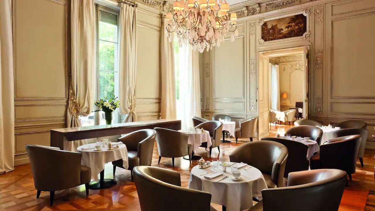 A luxury dining area with a few chairs and perfectly set tables.