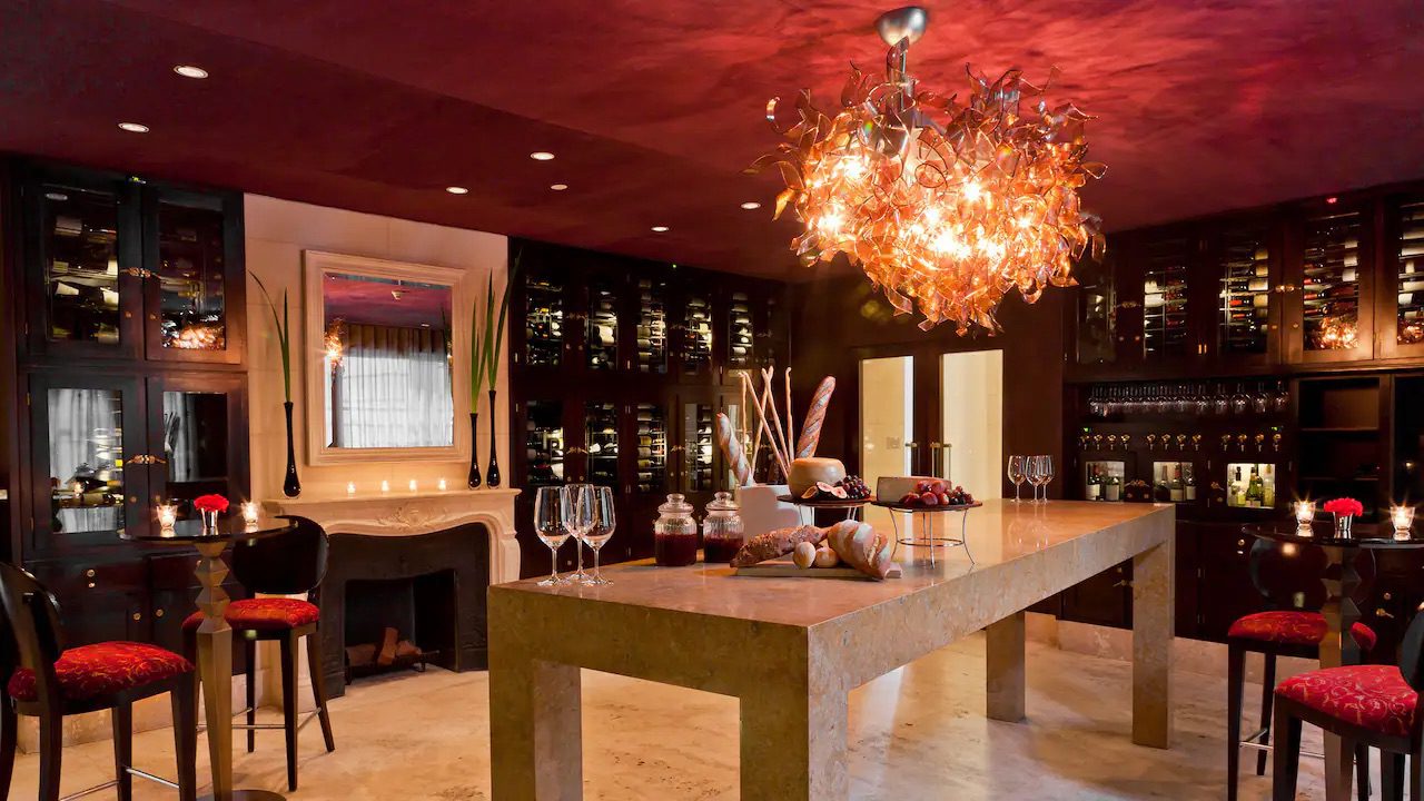 A quiet dining area with only a few tables and chairs and a large table with an array of food and wine glasses in the centre.