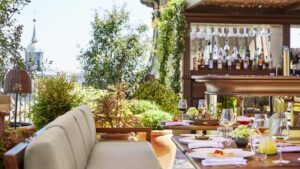 A luxury dining area with a bar, greenery and an incredible view of Madrid in the background.