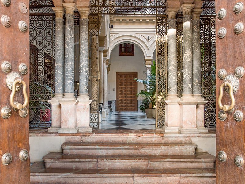 The grand entrance to Hotel Palacio de Villapanes with inviting marble steps and pillars.