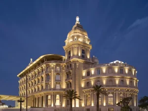 A view of the luxury hotel lit up in the evening.