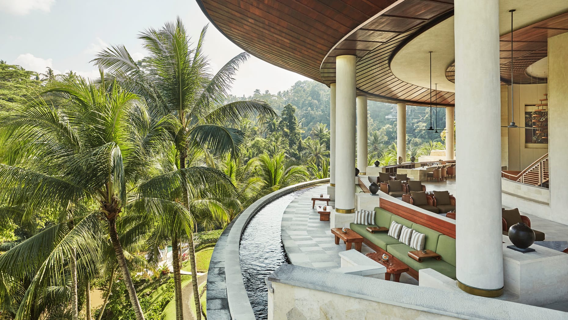 A view from the terrace, supported by grand pillars, complete with plenty of outdoor seating and tables, looking out onto the beautiful Indonesian scenery.