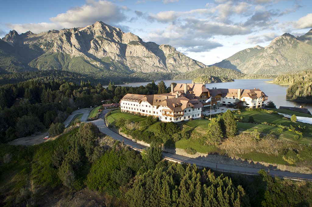 A view of the luxury hotel surrounded by greenery and incredible mountains behind.