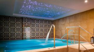 An indoor pool at the luxury spa with two water features flowing into the pool.