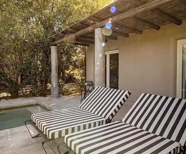 Large striped sun loungers on the private patio, complete with a private outdoor pool.