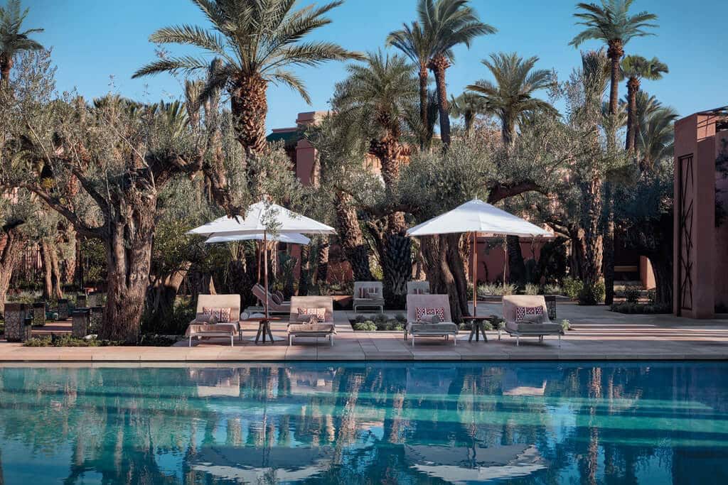 A large outdoor pool with sun loungers and umbrellas lining the pool edge, this area is enclosed with gorgeous palm trees and scenic greenery making it relaxing for the solo female traveller.