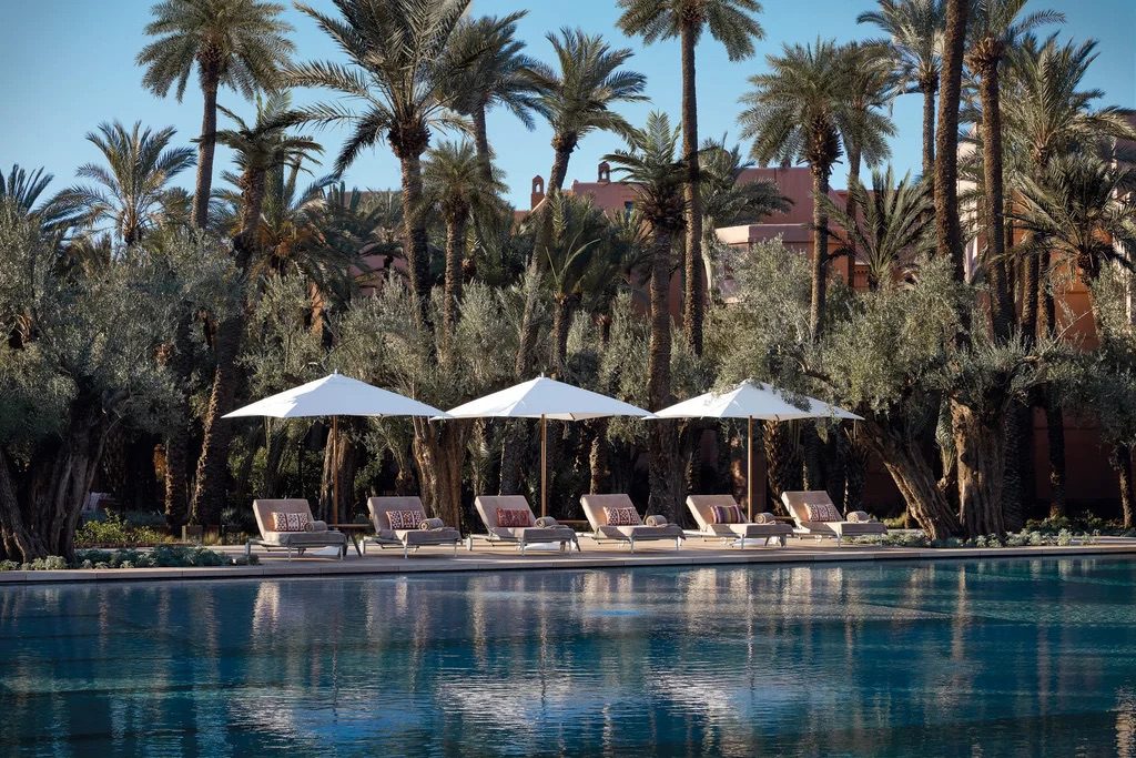 A large outdoor pool with sun loungers and umbrellas lining the pool edge, this area is enclosed with gorgeous palm trees and scenic greenery making it relaxing for the solo female traveller.