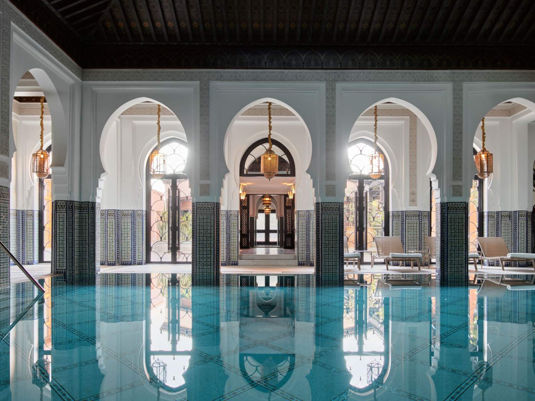 Luxury pool at the spa in La Mamounia, large windows letting in natural light and loungers beside the pool for a solo female traveller to relax.