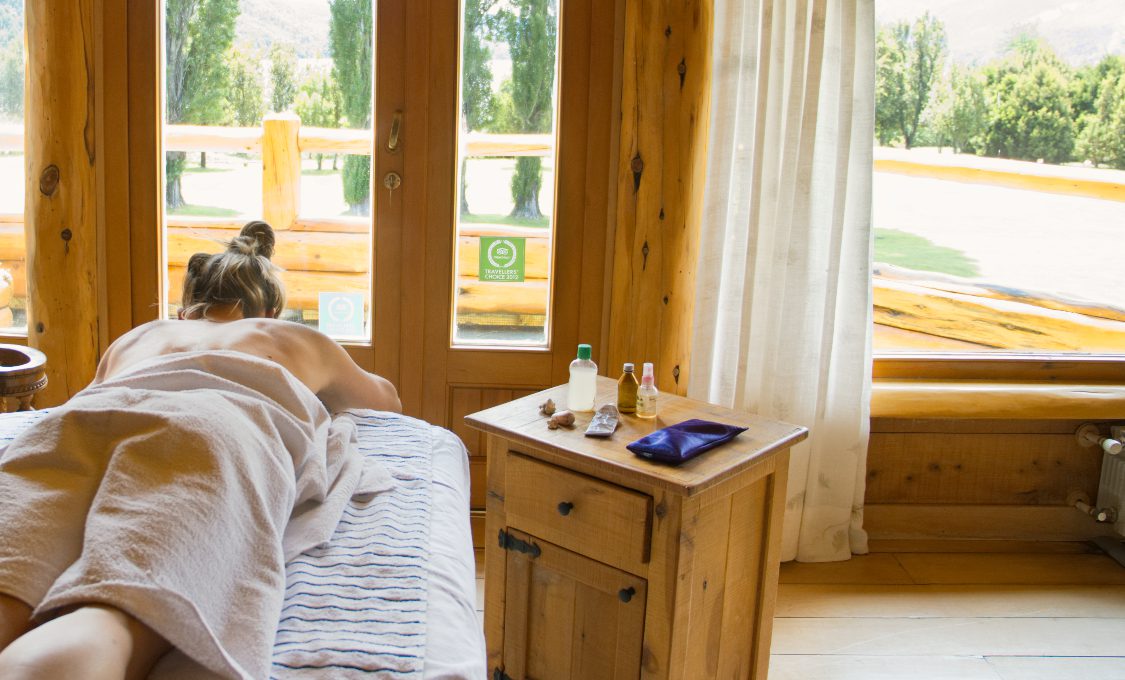 A woman laying down on a massage table in the luxury spa.