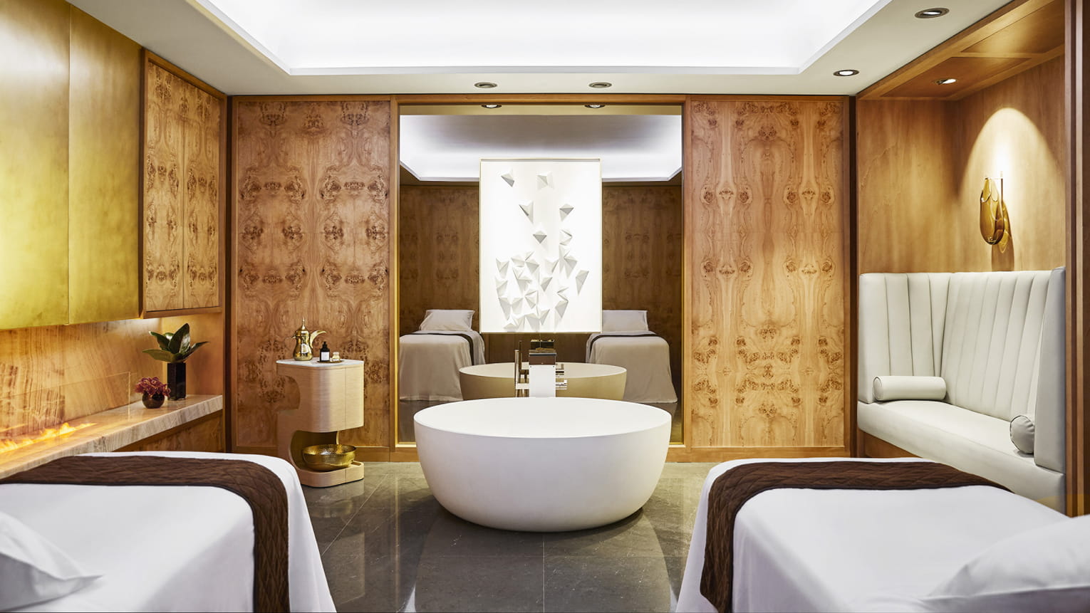 A luxury spa at the hotel featuring two massage tables and a free standing bath in the centre.