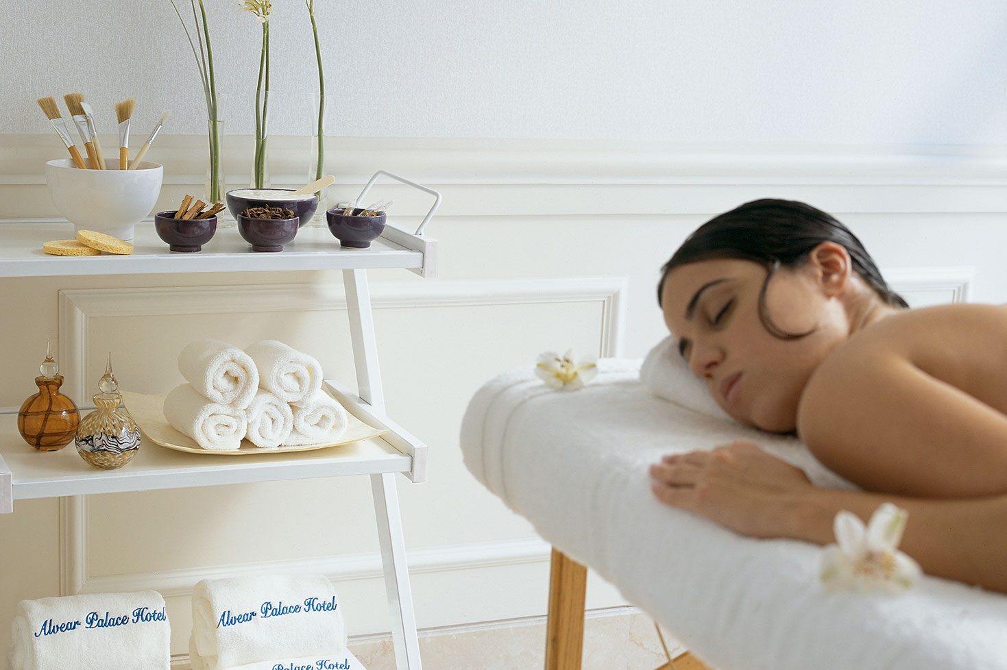 A woman laying down on a massage table in the luxury spa.