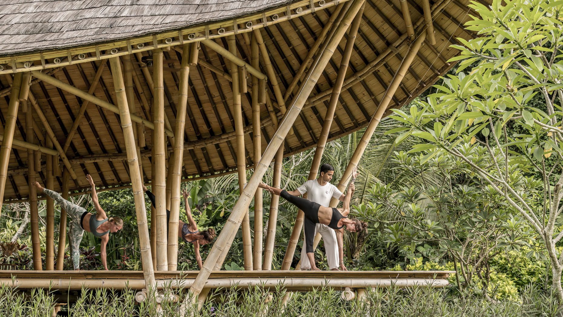 A small guided yoga and meditation class, held in the hotel's Sacred River Spa, surrounded by lush greenery.