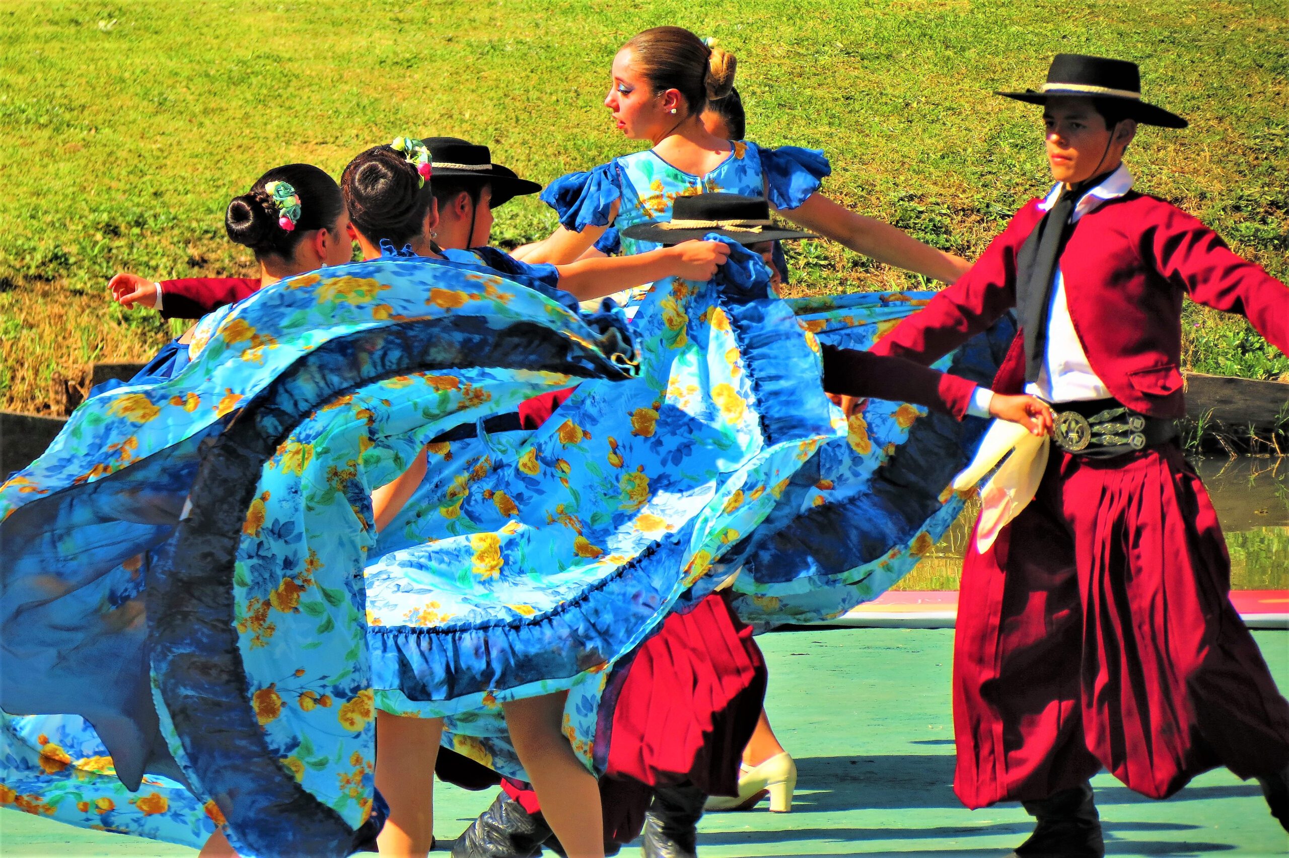 Dancers in traditional national costumes, dancing outside during a festival.