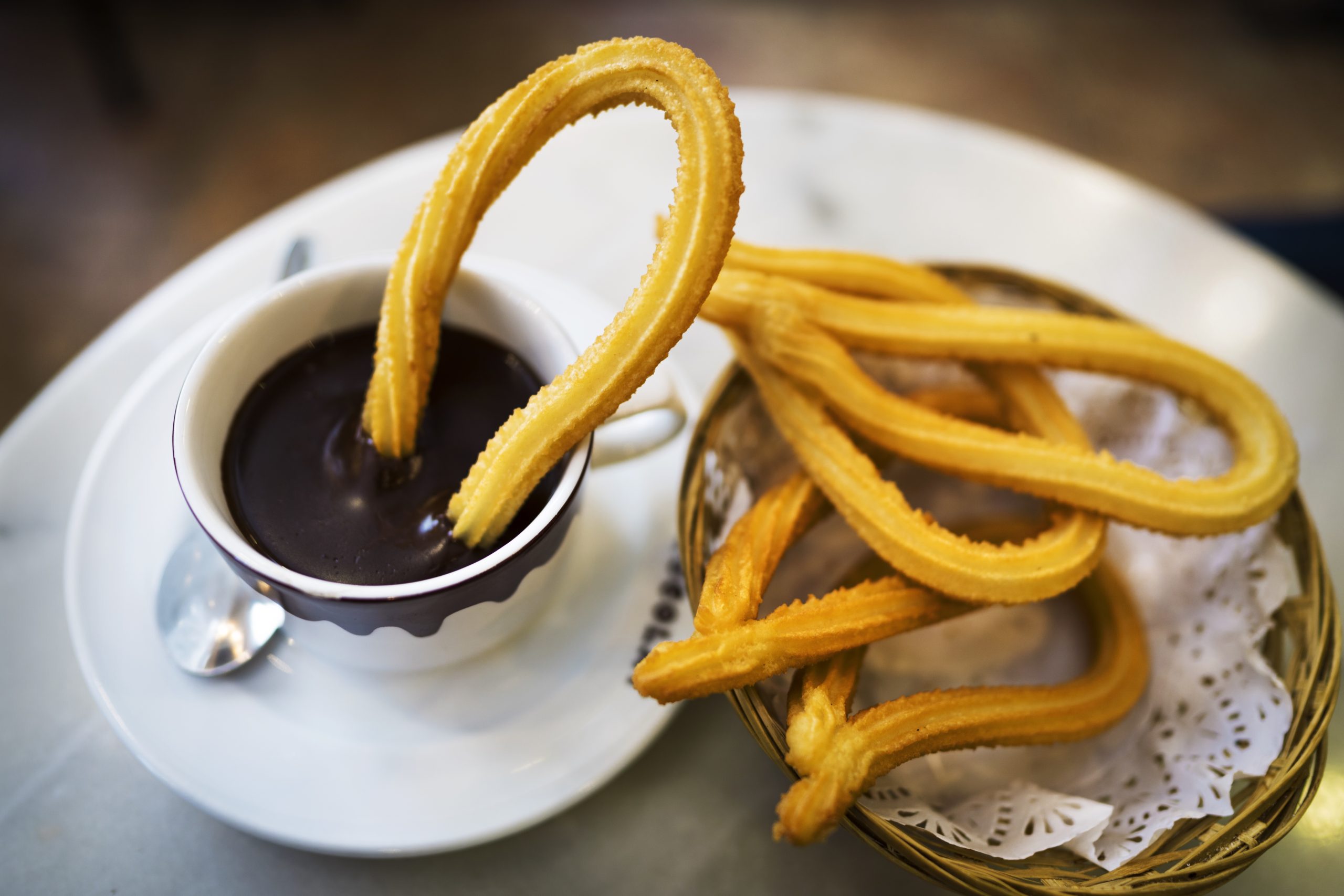 This image captured shows tradition and delicious fresh churros along side hot chocolate at a cafe in Spain.