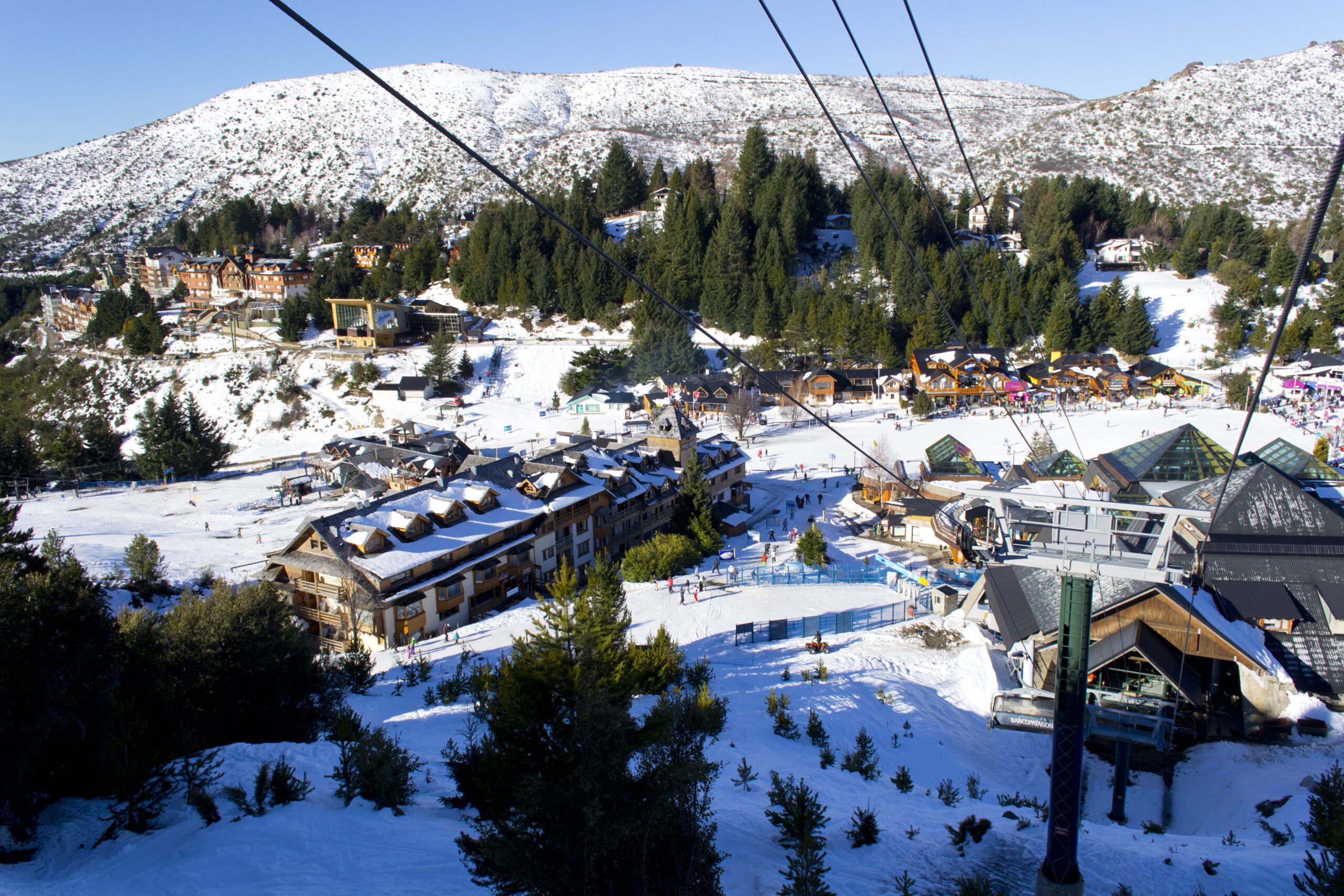 View of Bariloche from above in the winter from below teh cable car cables and hotel and town below