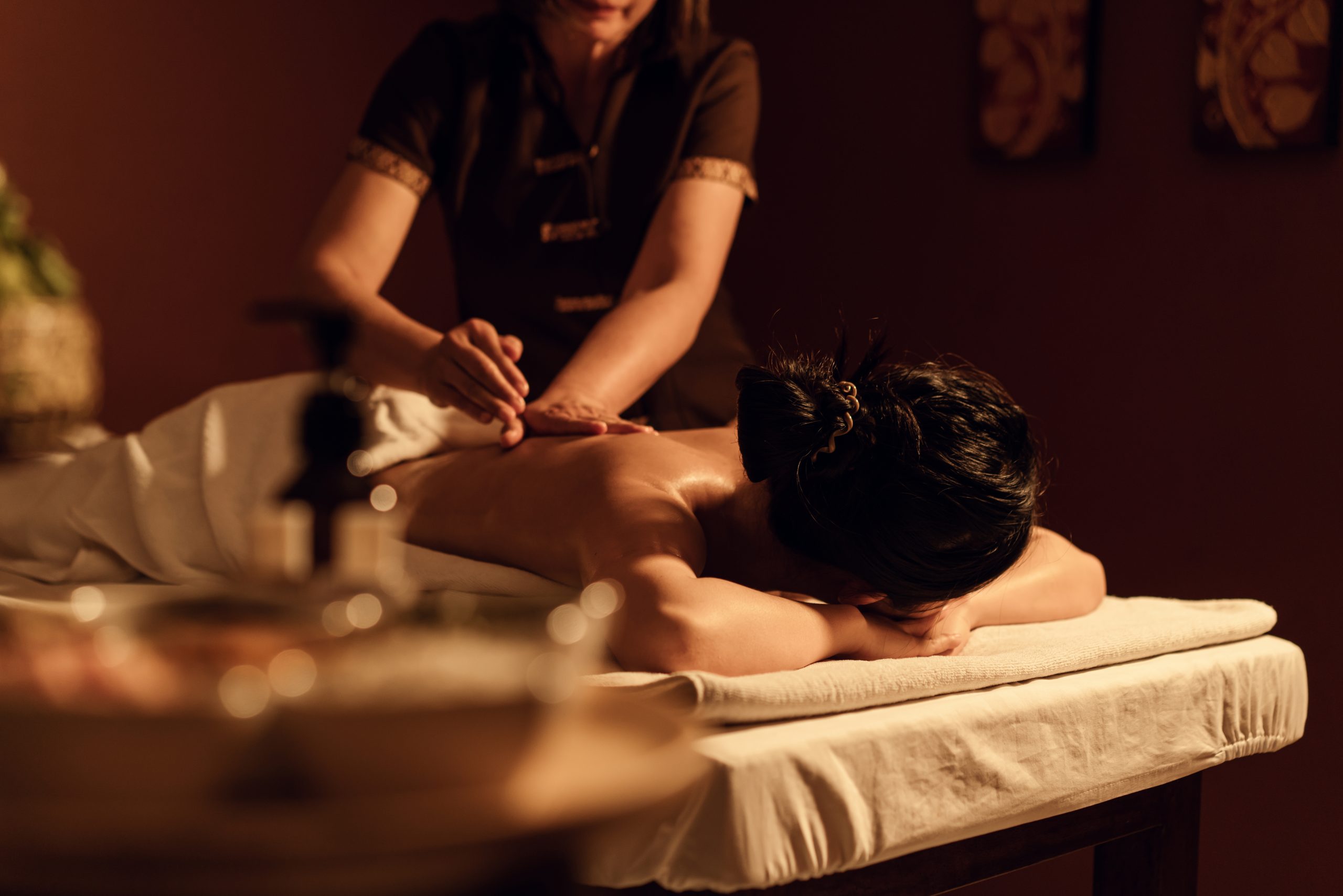 A woman laying on a massage table enjoying a massage at a luxury spa.