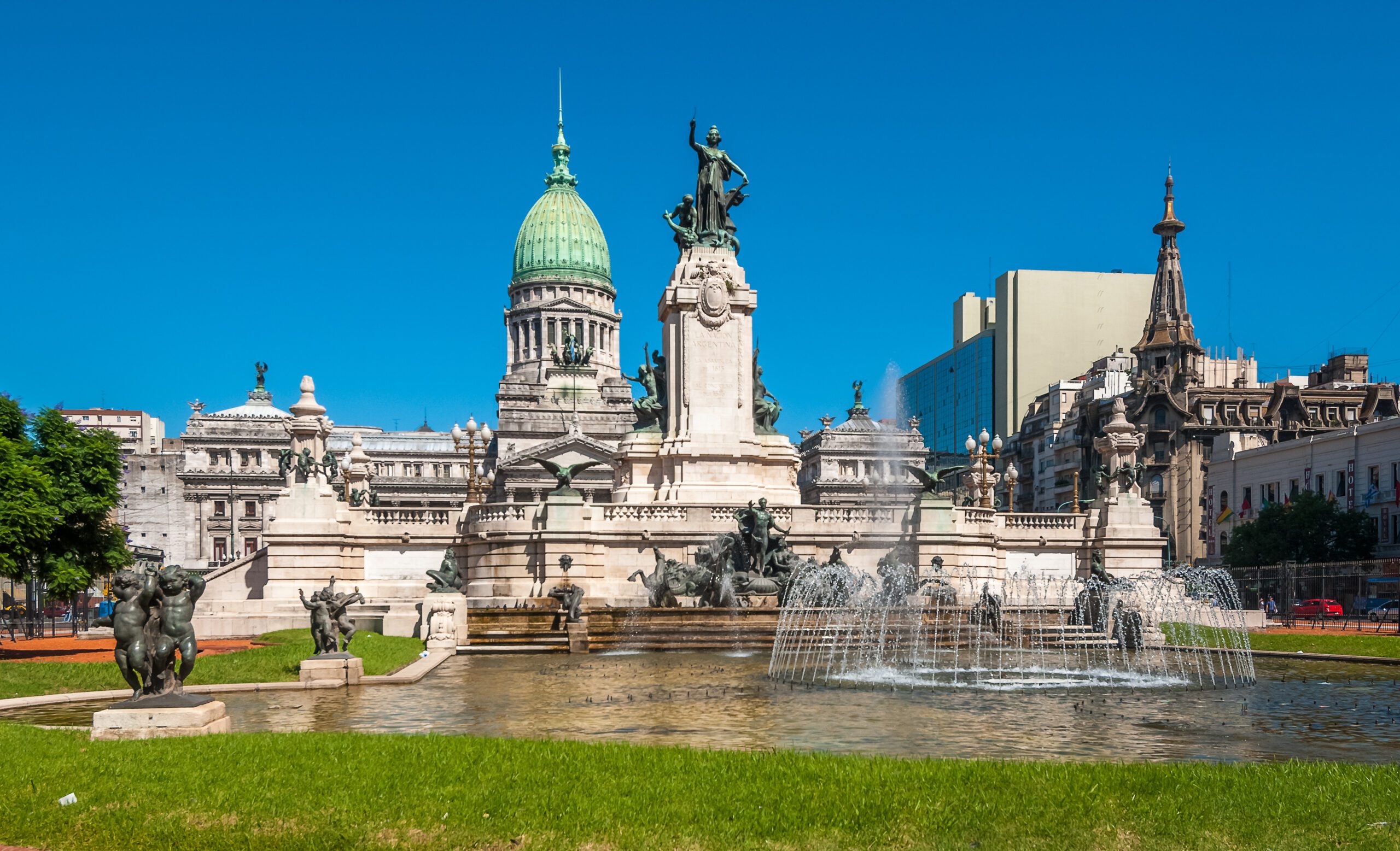 The National Congress building in Buenos Aires with a water fountain and an array of statures outside the building.