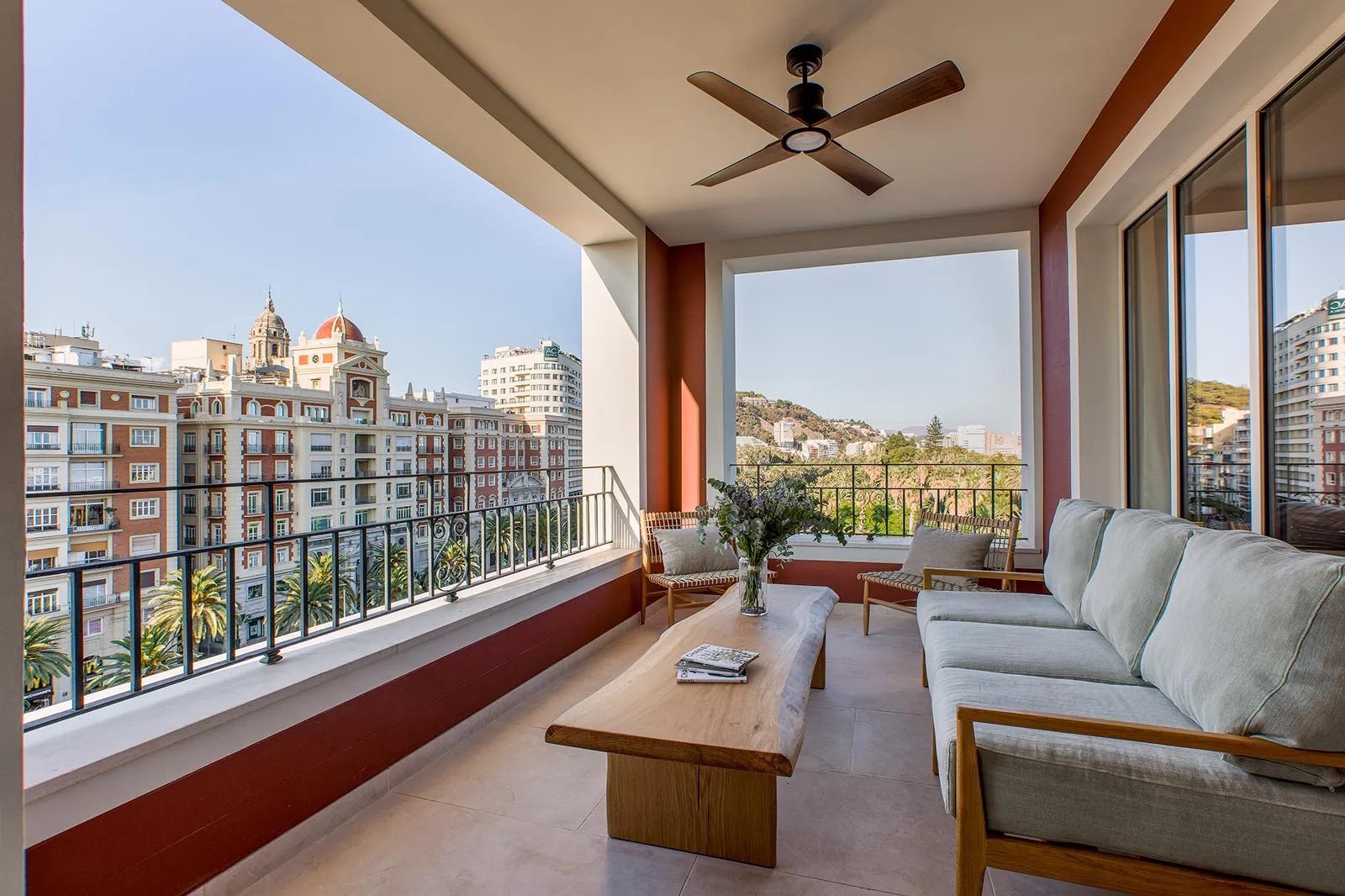 A private balcony at the luxury hotel, featuring two chairs, a three seater sofa, a table, complete with views of Málaga.