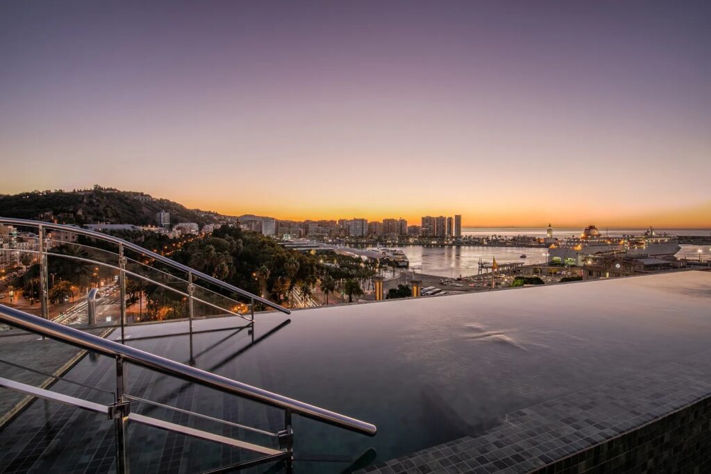 The infinity pool on the terrace of the luxury hotel, showcasing the incredible sunset and views of Málaga.