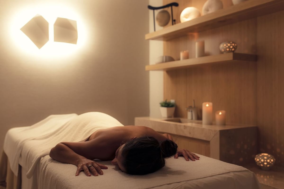 A woman laying down on a massage table in the luxury spa.