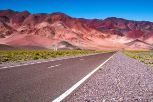 Image of a road heading into the deep purple-red-pink mountains in Salta in Argentina