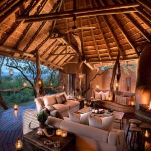 A luxury lounge area in the safari lodge with sofas, tables and candles lighting the room