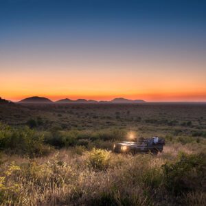 A safari vehicle with an incredible sunset in the background.