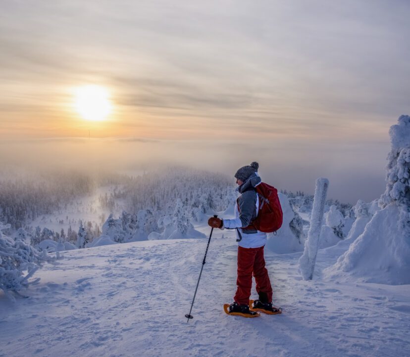 Woman snowshoeing on snowy mountain