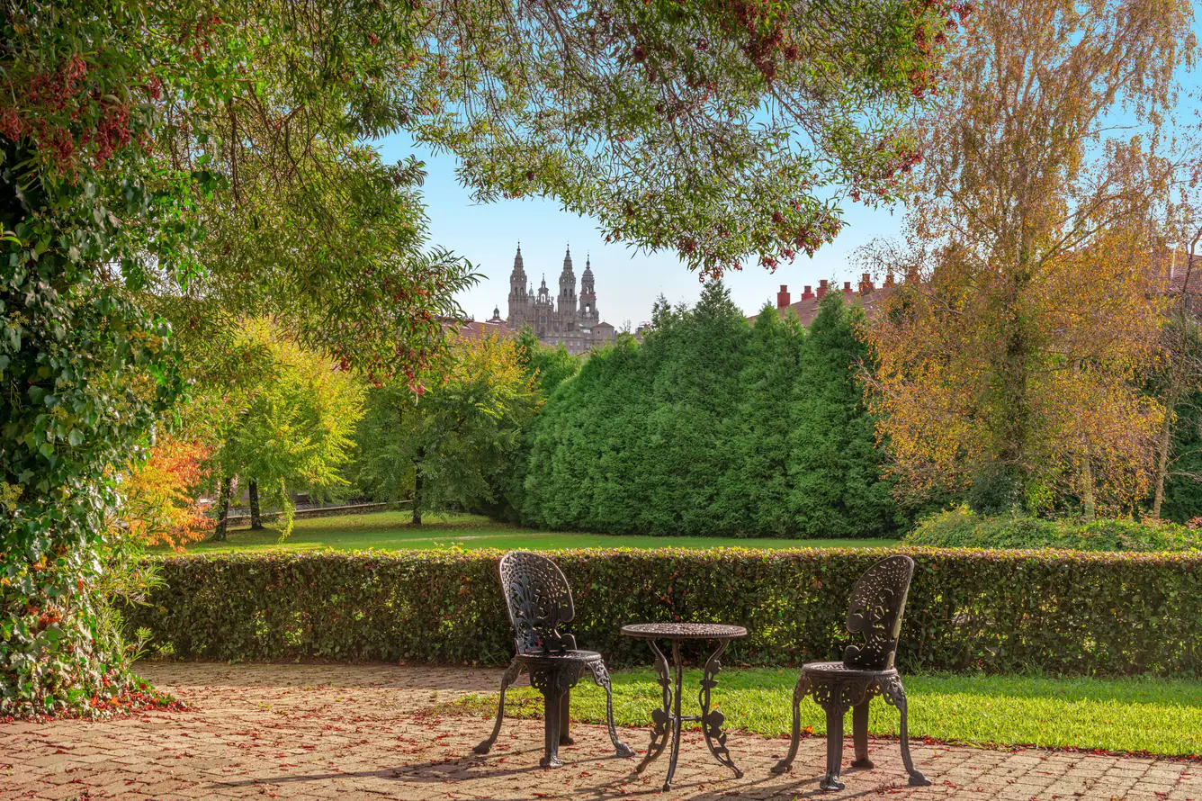 Outdoor seating in the garden of the luxury hotel with large expanses of greenery in the background.