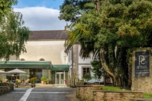 Entrance of the luxury hotel with a driveway lined with trees