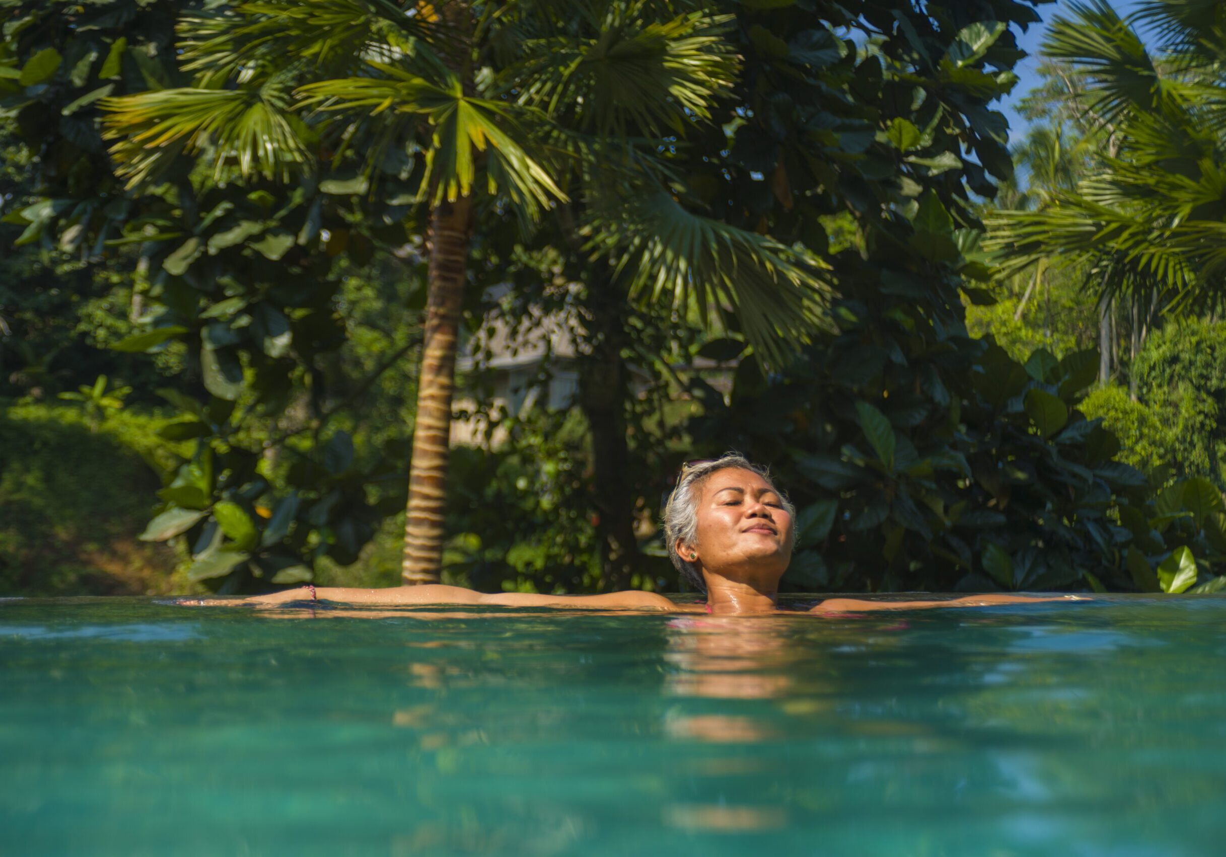 Luxury solo female traveller takes dip in invigorating pool