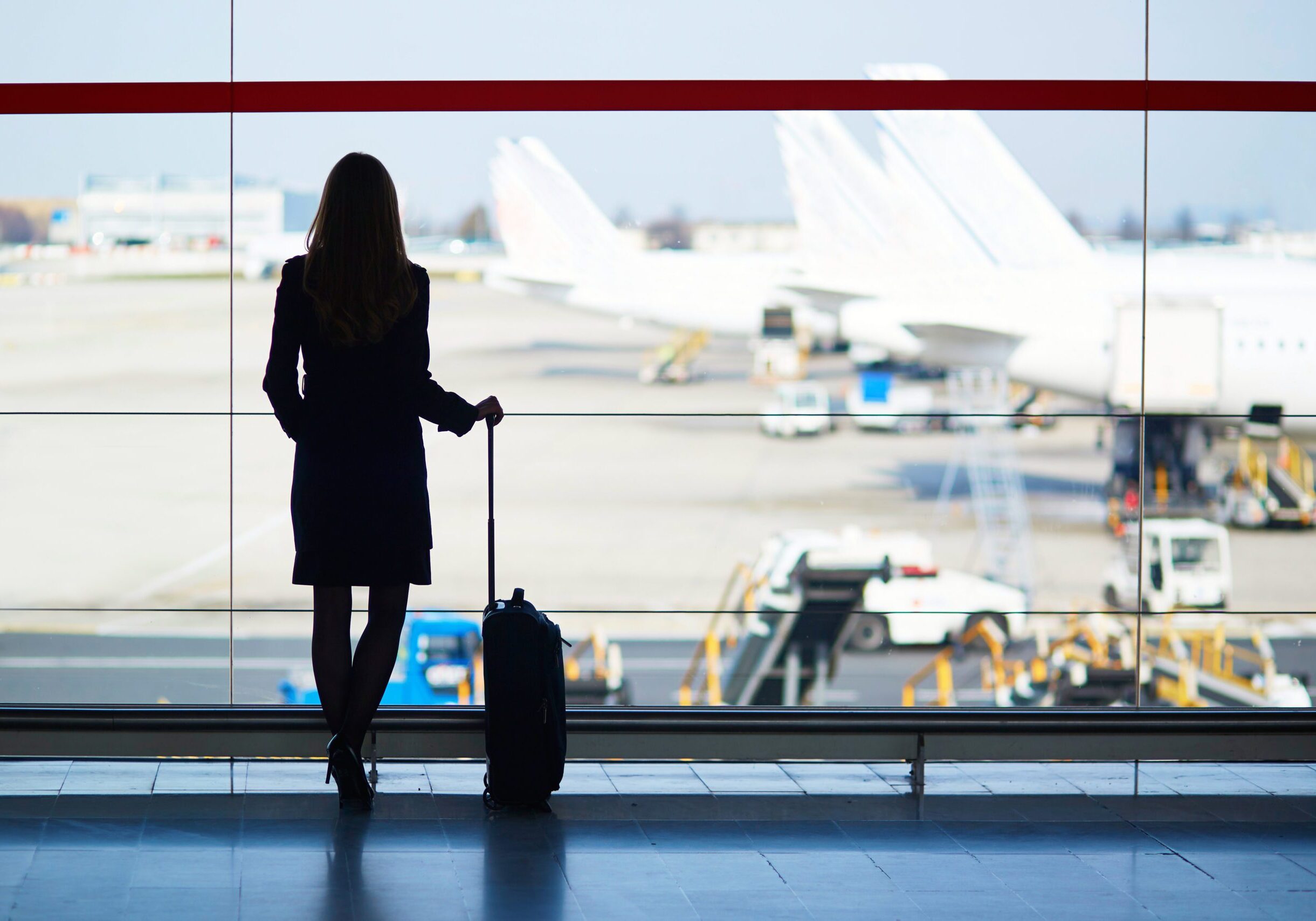 Woman travelling solo at an airport waiting for her flight to depart.