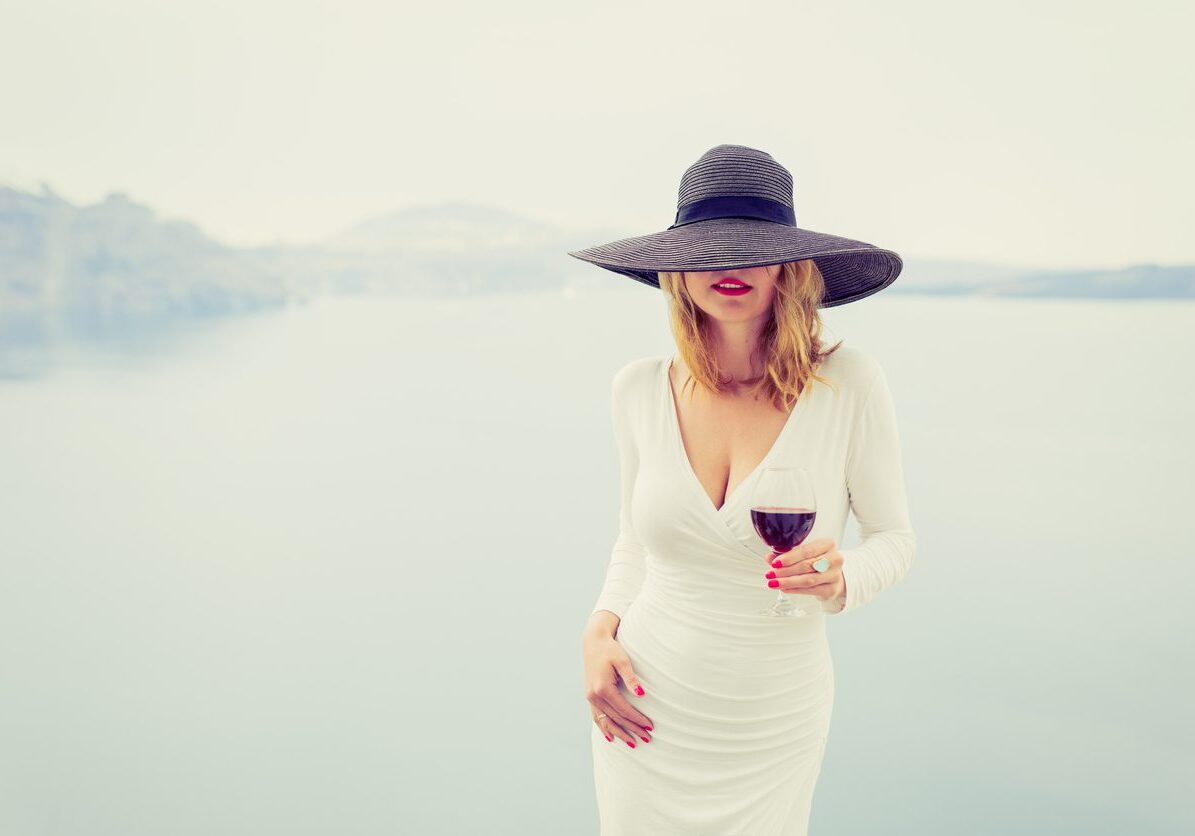 Woman enjoying glass of wine. Retro, vintage style filter.